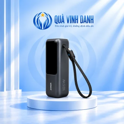 Minh họa một Anker A1695 xám đậm giữ màn hình tắt logo ANKER chữ 165W và vòng dây trên bục Quà Vinh Danh