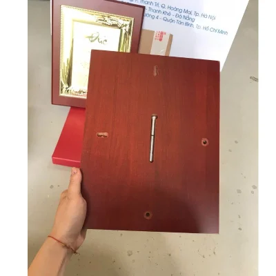 Ảnh thật mặt sau bảng vinh danh mẫu 05, có chốt kim loại và các rãnh trên nền đỏ nâu