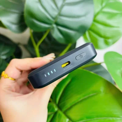 Ảnh thật cạnh Baseus FM12 đen giữ cổng USB-C màu vàng nhãn Input Output bốn điểm chỉ báo nút nguồn và toàn khung