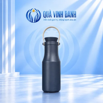 Bình giữ nhiệt xanh trơn dáng eo có quai vòng màu kem trên nền Quà Vinh Danh không bục