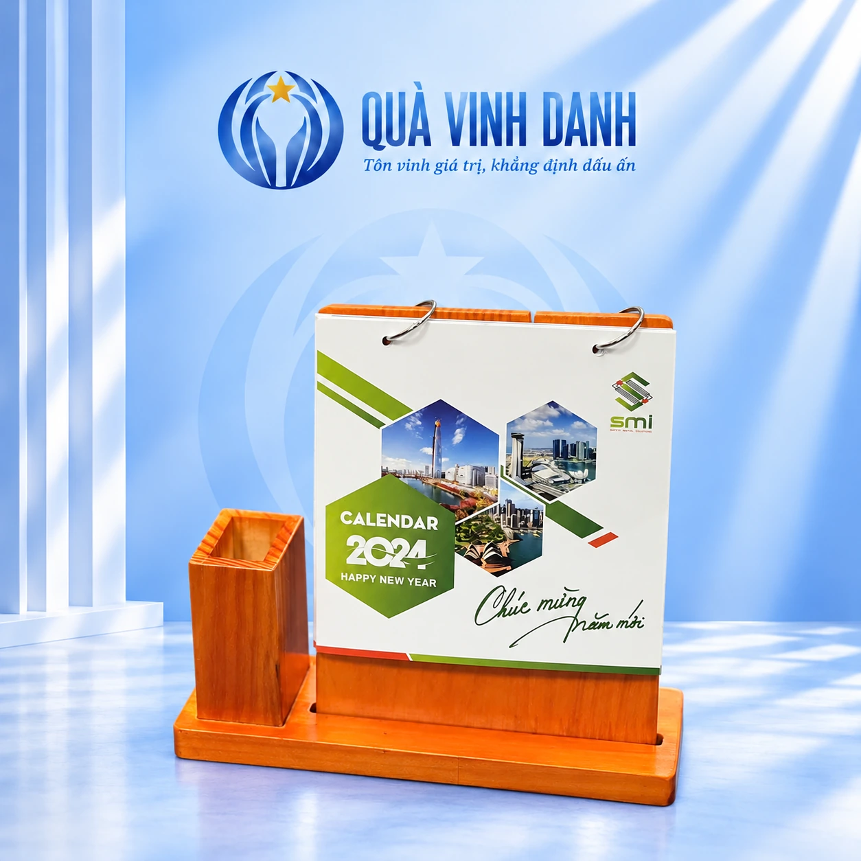 Minh họa bộ lịch đế gỗ hai khoen và ống bút vuông trên nền Quà Vinh Danh, giữ logo SMI, CALENDAR 2024 và lời Chúc mừng Năm mới