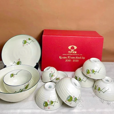 Ảnh thật hướng họa tiết đài sen giữ hộp đỏ TPVN TANAKA PRECISION VIETNAM CO LTD kỷ niệm mười năm 2013 2023 và dấu dưới đáy