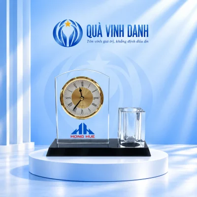 Minh họa bộ pha lê đồng hồ mặt tròn và ống bút khối vuông trên bục Quà Vinh Danh, giữ biểu trưng xanh cùng HONG HUE đỏ