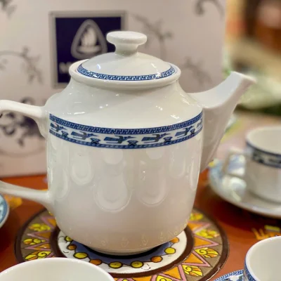 Ảnh chụp nguồn cận ấm Jasmine Chim Lạc, quai vuông bên trái, vòi thẳng bên phải, nắp thấp và dải chim xanh