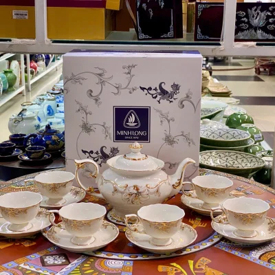 Ảnh chụp nguồn toàn bộ trà Đài Các với một ấm, sáu chén và sáu đĩa, giữ hộp MINHLONG SINCE 1970 phía sau