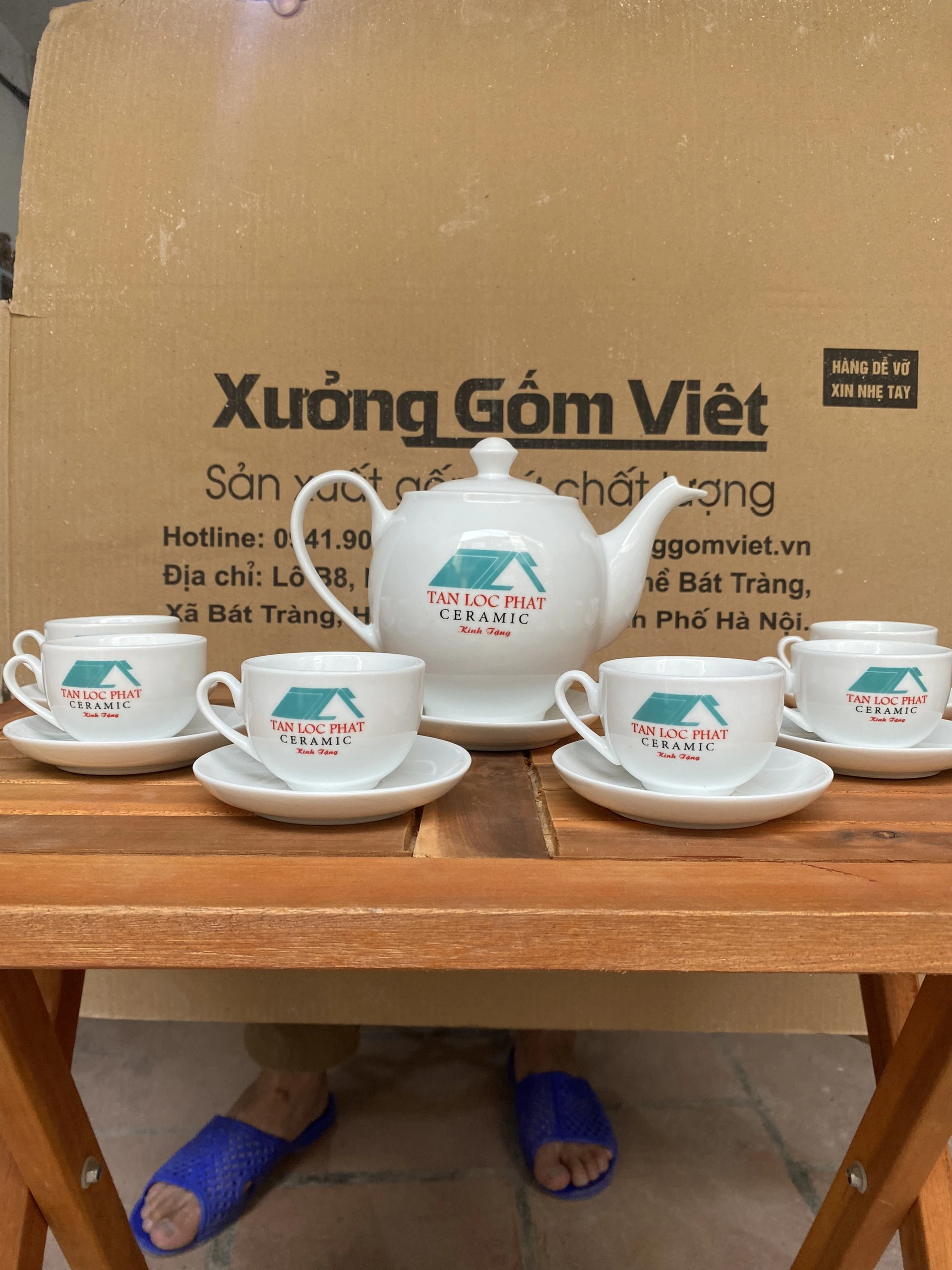 Ảnh thật nguồn bộ trà trắng in biểu trưng xanh TAN LOC PHAT CERAMIC Kính Tặng trên ấm và chén, giữ toàn khung bàn chụp