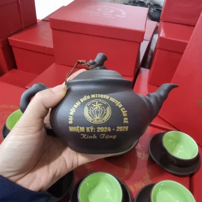 Ảnh chụp nguồn cận ấm mẫu 14 có dây nối nắp với quai, giữ biểu trưng MTTQVN Huyện Cầu Kè nhiệm kỳ 2024–2029 Kính Tặng