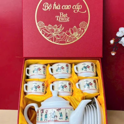 Ảnh nguồn hộp trà đỏ mở nắp, sáu chén, một ấm và đĩa trên lớp vải vàng, giữ chữ Bộ trà cao cấp Bat Trang Vietnam