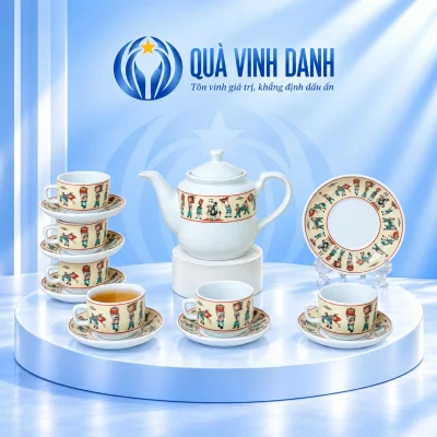 Bộ trà Vinh Quy Bái Tổ với một ấm, sáu chén và bảy đĩa trên nền có bục Quà Vinh Danh