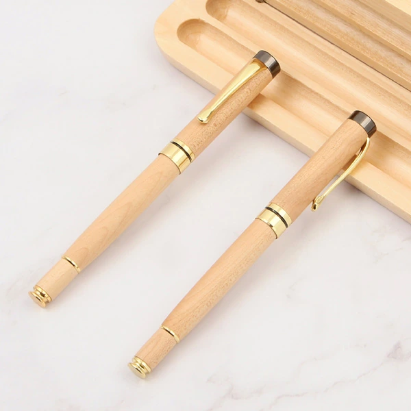 Ảnh nguồn hai bút gỗ BGV 003 đóng nắp với cài vàng và chóp xám đậm cạnh khay gỗ