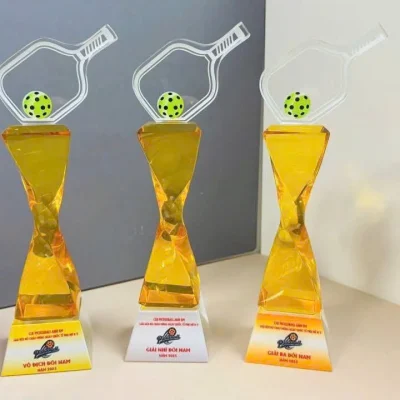 Ảnh mẫu nguồn chụp ba cúp Pickleball thân vàng có nội dung giải trên đế