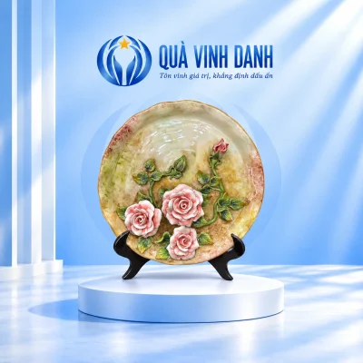Đĩa biểu trưng đắp nổi hoa hồng 30 cm với đế gỗ đen trên bục trắng trong nền Quà Vinh Danh