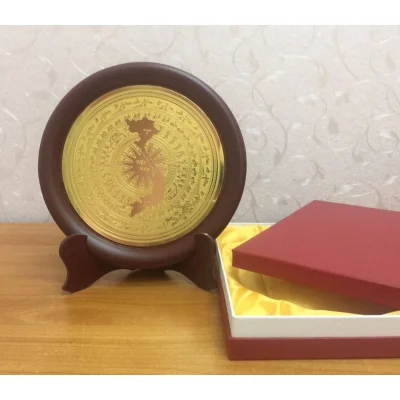 Ảnh chụp nguồn đĩa mặt hoa văn trống đồng và hình bản đồ Việt Nam, đặt cạnh hộp đỏ lót vàng