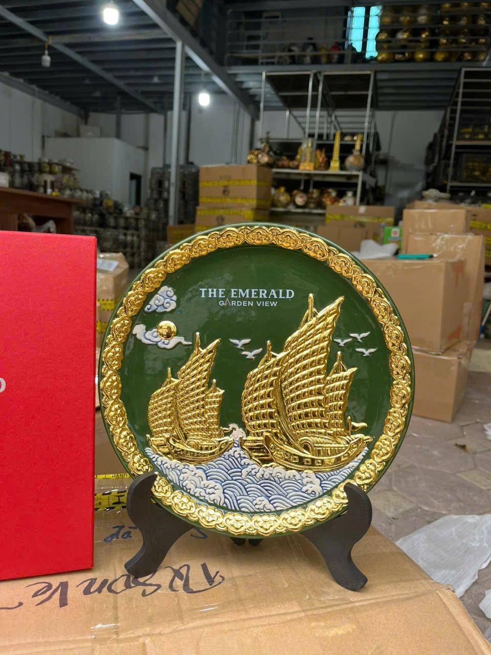 Ảnh chụp gần nguồn giữ nguyên hai thuyền màu vàng, sóng xanh trắng, viền nổi và hai dòng tên trên nền xanh