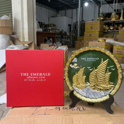 Ảnh chụp nguồn đĩa thuyền buồm nền xanh và hộp đỏ, giữ nguyên chữ THE EMERALD GARDEN VIEW cùng các thông tin gốc