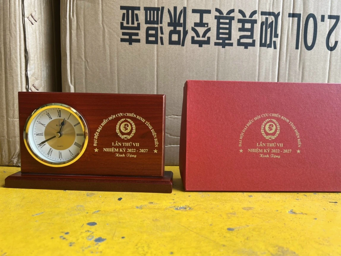 Ảnh chụp nguồn đồng hồ gỗ 02 và hộp đỏ, giữ huy hiệu, Hội Cựu chiến binh tỉnh Điện Biên, lần thứ VII, nhiệm kỳ 2022–2027 và Kính Tặng