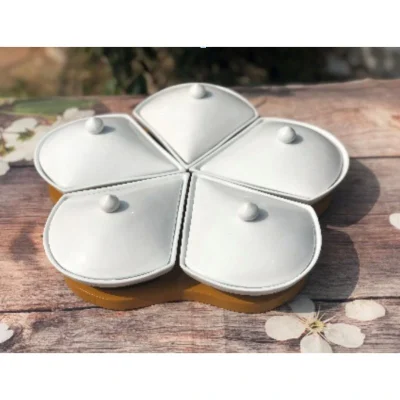 Ảnh nguồn bộ khay mứt năm cánh khế trắng đóng nắp trên bàn gỗ với hoa trắng bên cạnh