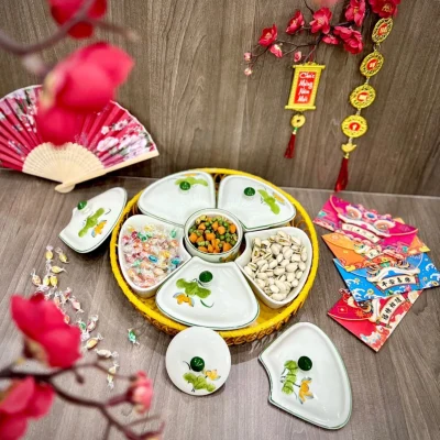 Toàn bộ khay mứt sen vàng có ba hộp mở nắp và các nắp rời đặt cạnh khay mây