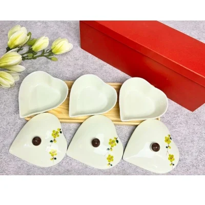 Ảnh nguồn ba lòng hộp tim mở nắp trên khay gỗ, ba nắp hoa vàng đặt phía trước