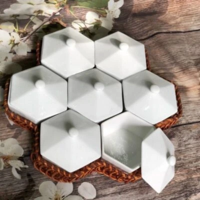 Ảnh nguồn nguyên khung bộ khay mứt tổ ong bảy hộp trắng đặt trên bàn gỗ cạnh hoa trắng