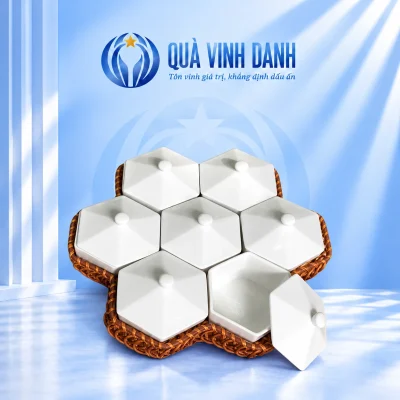 Bộ khay mứt tổ ong bảy hộp lục giác trắng trên khay đan nâu, một hộp mở phía trước bên phải
