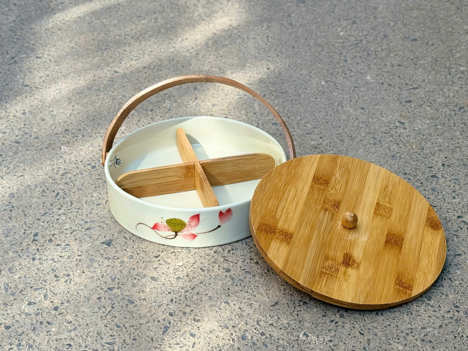 Ảnh nguồn khay tròn mở nắp, lòng chia bốn ngăn và quai vòm