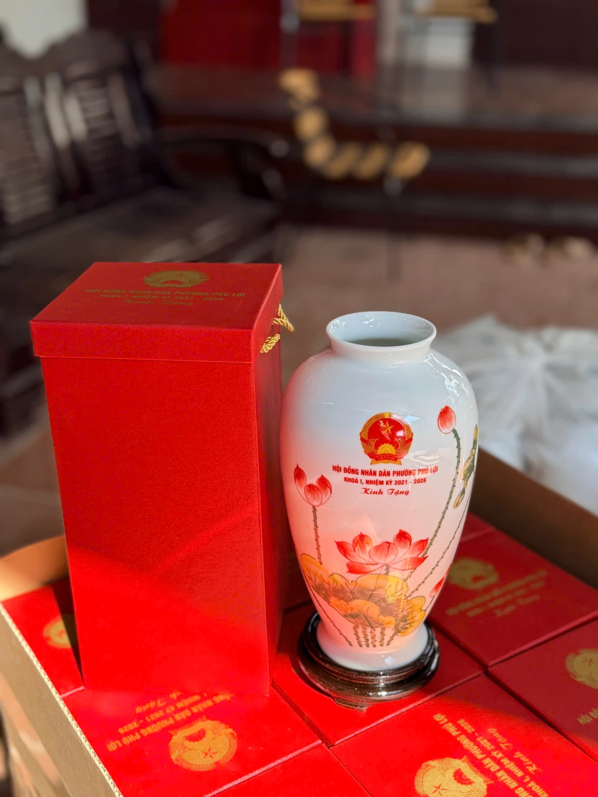 Ảnh gốc nhìn rõ miệng mở và vai tròn của lọ hoa sen đỏ bên hộp đỏ