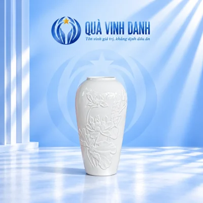 Lọ hoa men trắng thân thuôn, vai bo và hoa lá sen nổi cùng màu trên nền Quà Vinh Danh