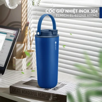 Ảnh catalog ly Elmich xanh navy trên sách cạnh cửa sổ giữ logo hãng dòng INOX304 EL8312NB600ML và toàn bối cảnh