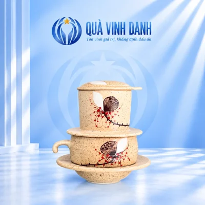 Bộ phin cà phê đài sen men kem đặt trên nền xanh Quà Vinh Danh không bục