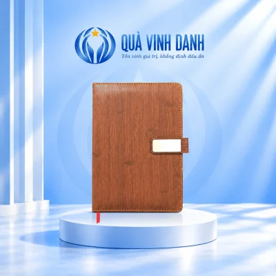 Minh họa sổ SD52-A5 nâu bìa PU vân sọc với tai bìa chữ nhật màu bạc trên bục Quà Vinh Danh