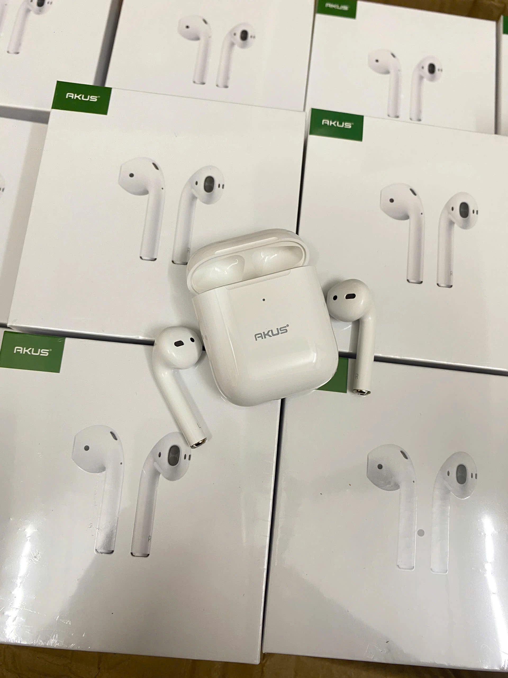 Ảnh chụp nguồn AKUS A2 gồm hộp trắng mở rỗng và hai tai thân dài đặt rời hai bên trên các hộp in hình tai nghe giữ toàn bộ chữ logo
