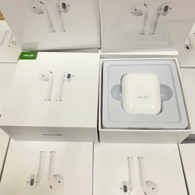 Ảnh chụp nguồn hộp AKUS A2 trắng đóng nắp nằm trong khay hộp màu trắng xung quanh có bao bì in hình tai nghe và nhãn AKUS xanh giữ nguyên toàn khung