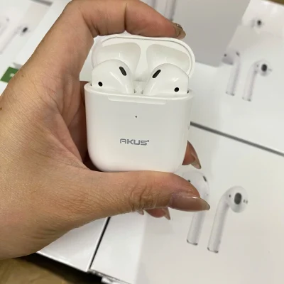 Ảnh chụp nguồn hộp AKUS A2 trắng mở trong tay có hai tai nghe bên trong chấm nhỏ phía trước logo hãng và các hộp nền giữ nguyên khung