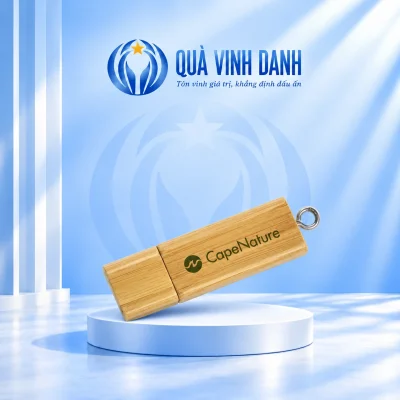 Ảnh đổi nền USB gỗ UGV 001 đóng nắp giữ chữ biểu tượng CapeNature màu xanh đường ráp nắp bên trái và vòng nối cuối trên bục Quà Vinh Danh