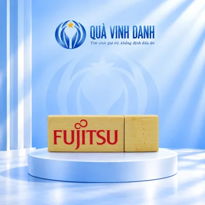 Ảnh đổi nền một USB gỗ UGV 006 đóng nắp bên phải giữ chữ FUJITSU đỏ đường ráp và vân gỗ trên bục Quà Vinh Danh