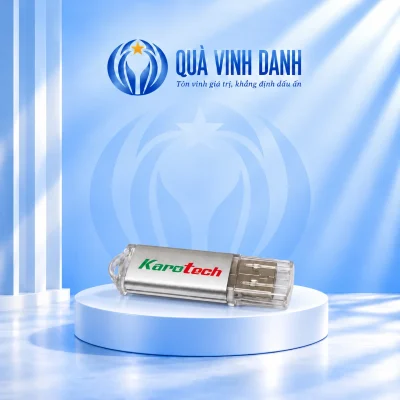 Ảnh đổi nền USB UKV 024 bạc đóng nắp trong bên phải giữ chữ Karotech xanh đỏ và điểm nối trong bên trái trên bục Quà Vinh Danh