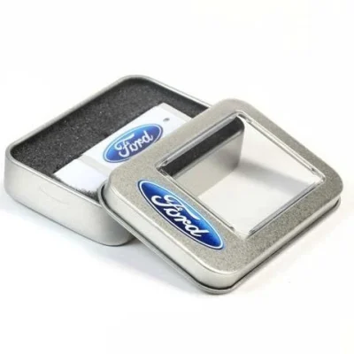 Ảnh nguồn USB trắng chữ Ford trong hộp có phần đệm tối và nắp cửa sổ giữ nguyên hai logo xanh